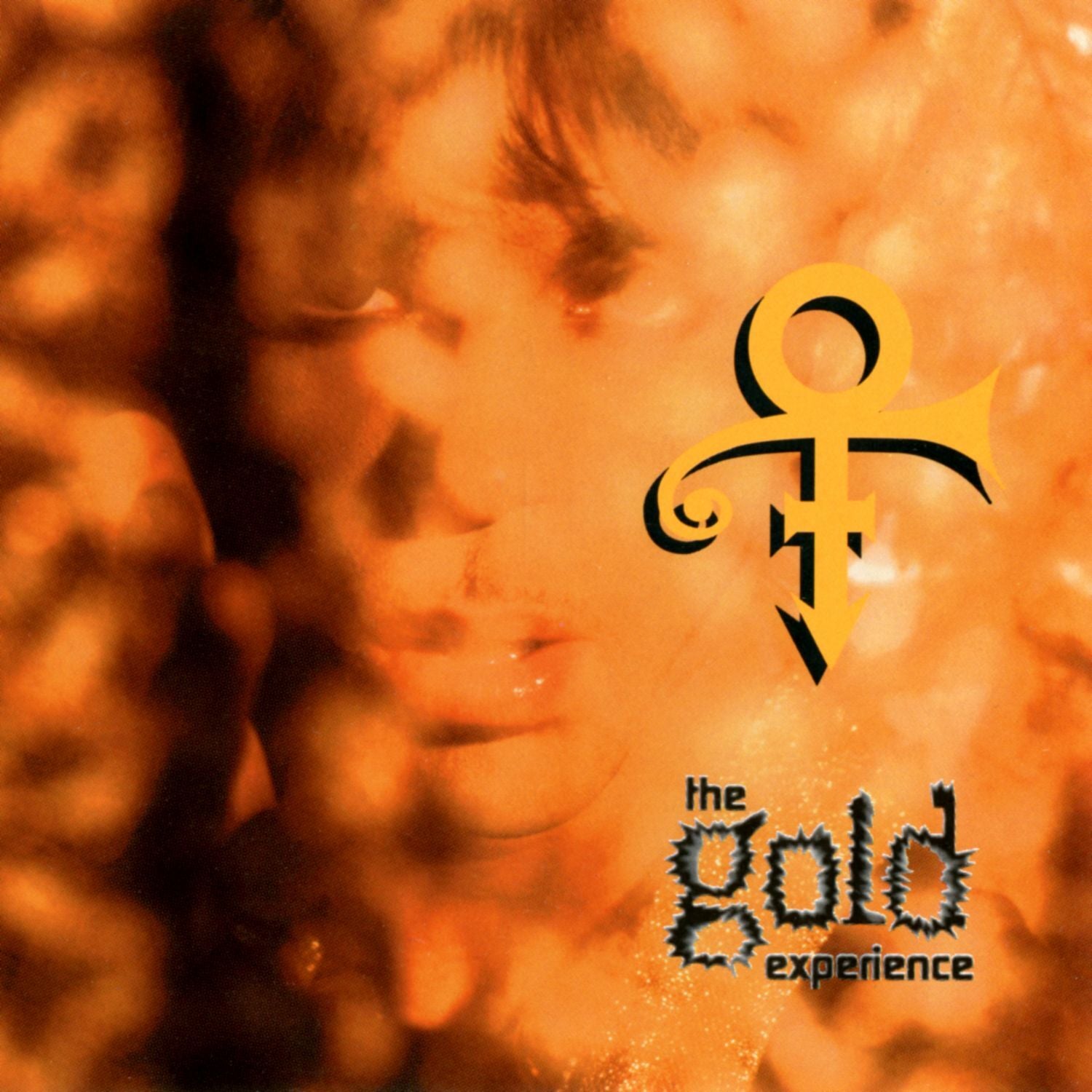 Album cover with a stylized face and 'the gold experience' text on an orange background